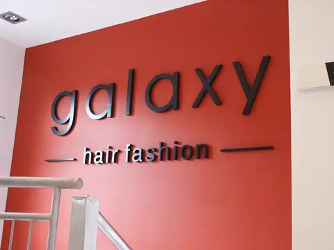 Logo galaxy hair fashion na czerwonej ścianie