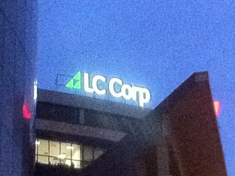 Świecące logo LC Corp o zmierzchu