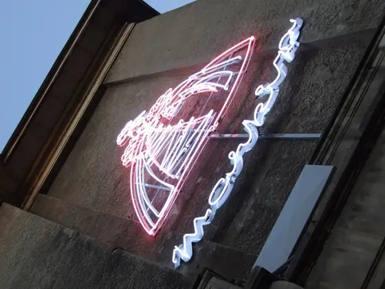Odtworzony neon Markiza świecący nocą na elewacji